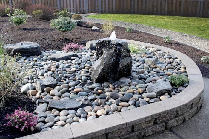 Bubbling boulder fountain in landscaped dry creek bed. Bubbling boulder fountain in landscaped dry creek bed.